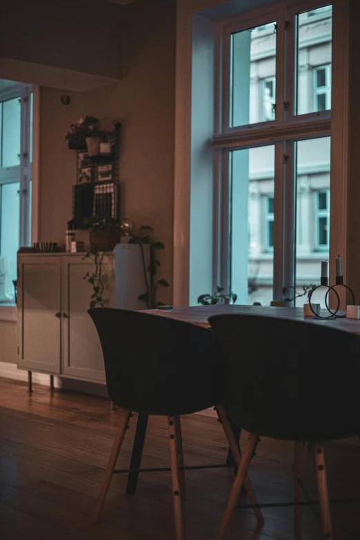 an empty table in front of three large windows