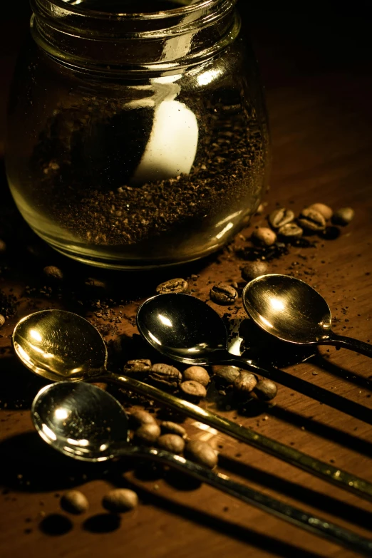 spoons and jars filled with food sitting on top of a table