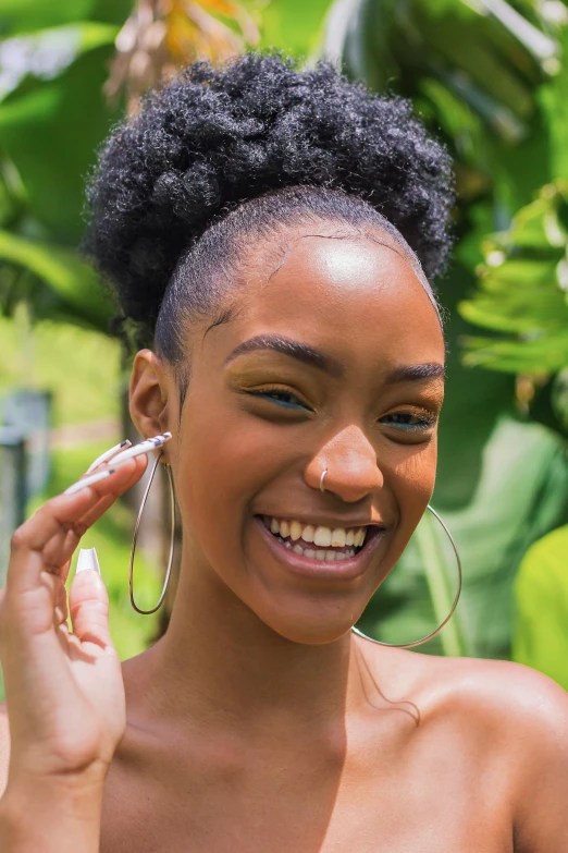 a woman smiling and holding up her nose