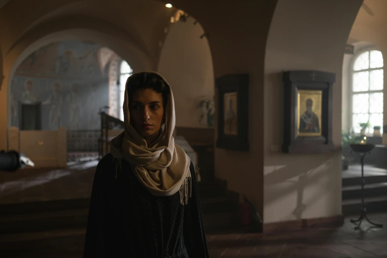 woman standing in large room with several paintings on walls