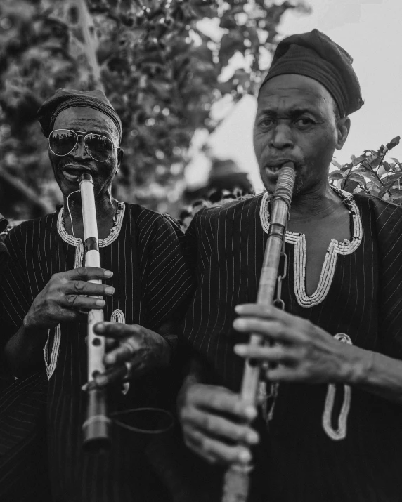 two women playing flutes next to each other