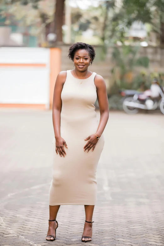 woman in tan dress posing for picture outside