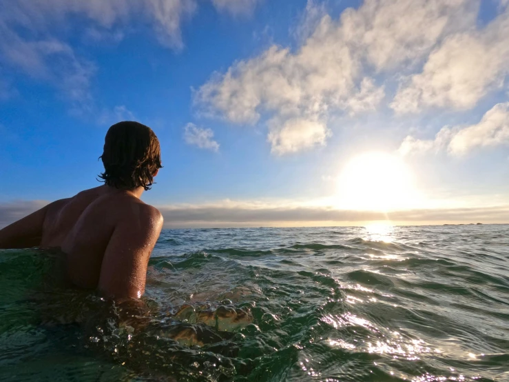 a person swimming in the ocean with a frisbee