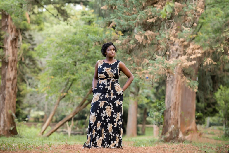 a young woman is standing in a forest