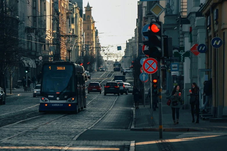 a bus driving down a street next to tall buildings