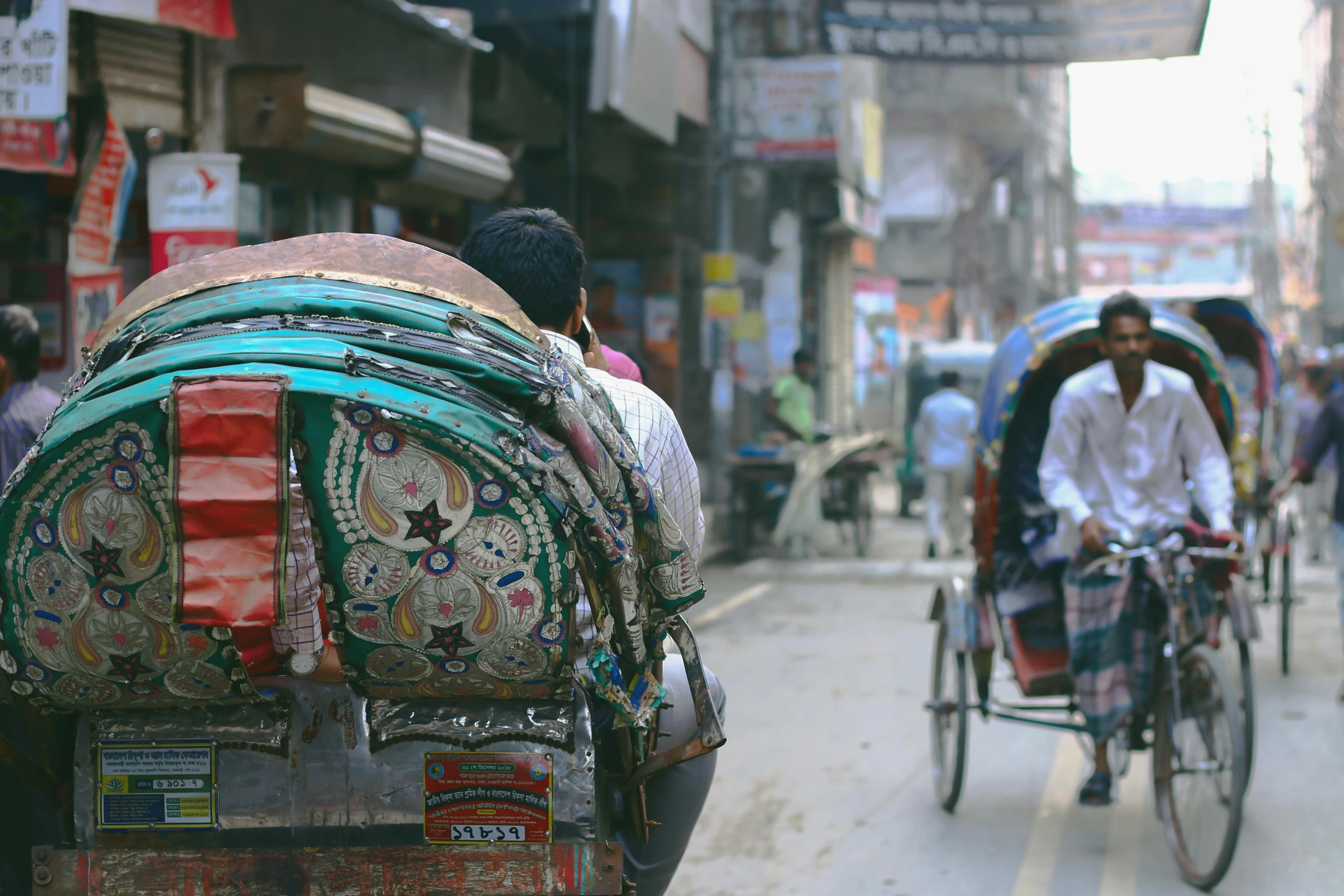 three people hing carts and bicycles in the street