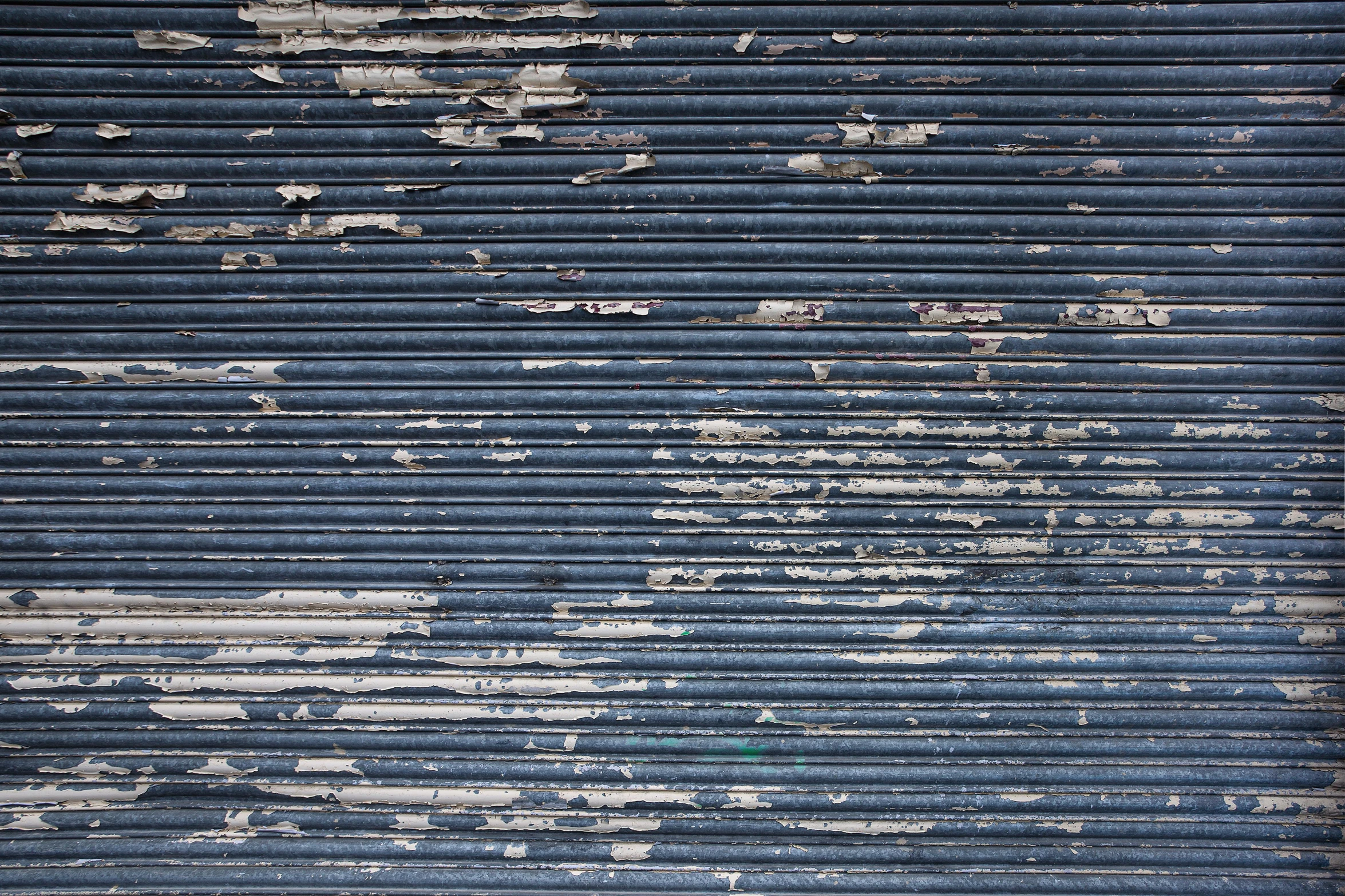 an old, rusted warehouse door that has some blue paint