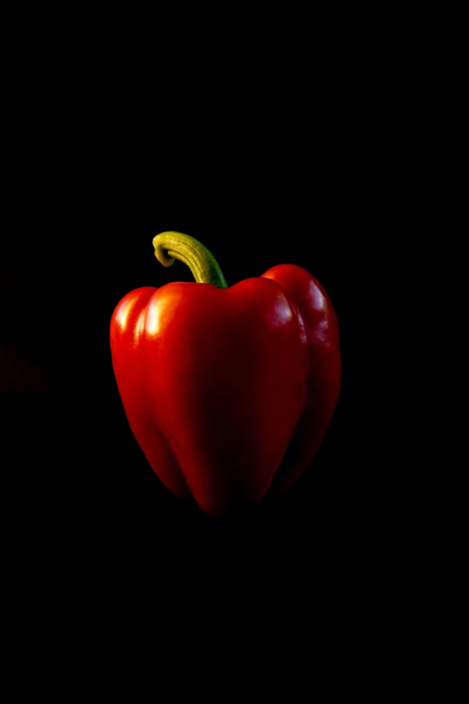 a pepper that is red and yellow with a green stem