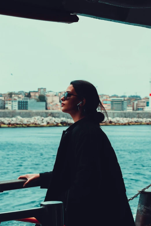 woman in dark dress standing on the deck of ship