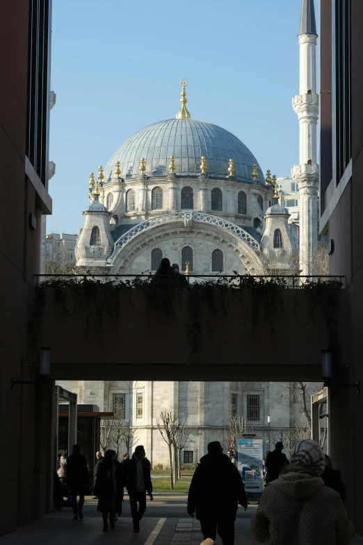 people walking down the street in front of a large building