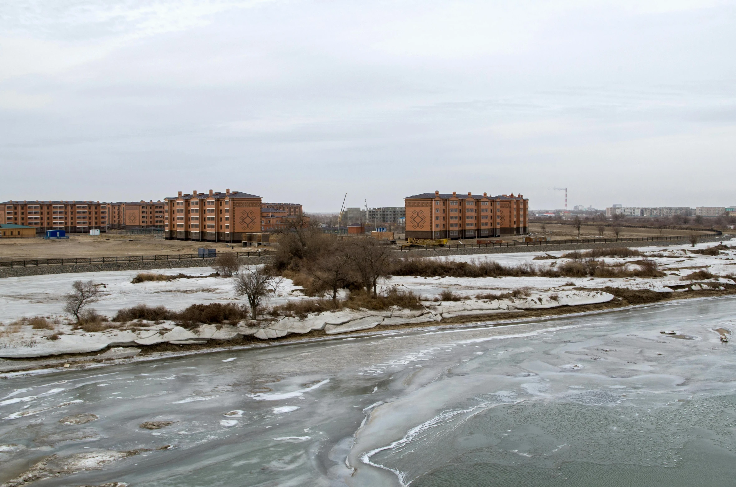 the ice covered river runs through an urban area