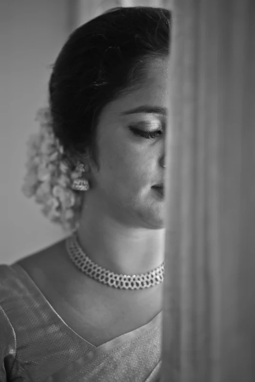 black and white image of woman with an old fashion necklace