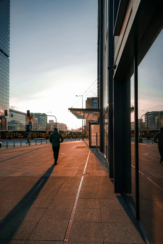 two people walking down an empty street between tall buildings