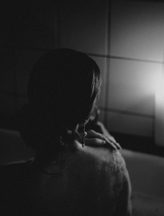 a woman looks at herself in the dark