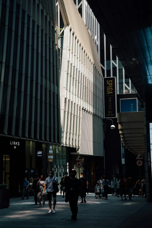 people walk by some big buildings in a large city