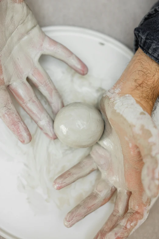 a person with dirty hands standing over the sink