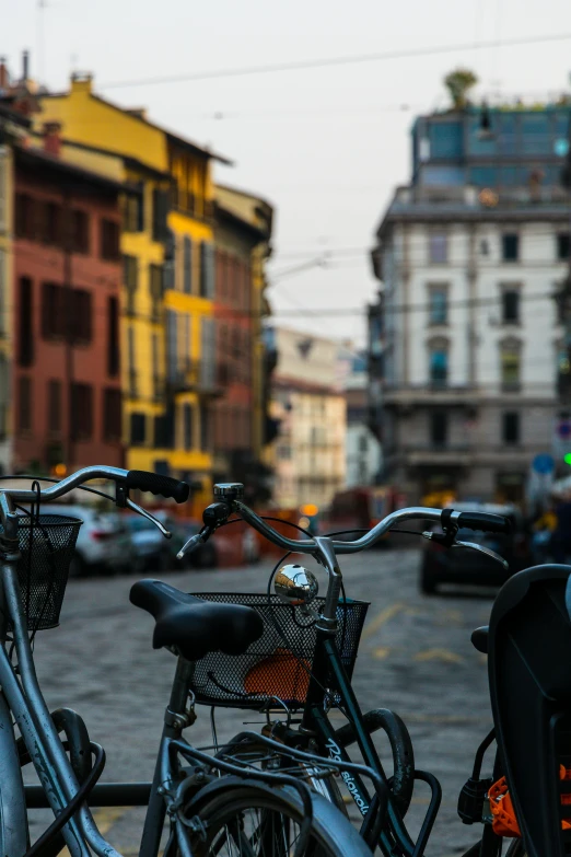 bicycles parked on the side of a street with cars parked nearby