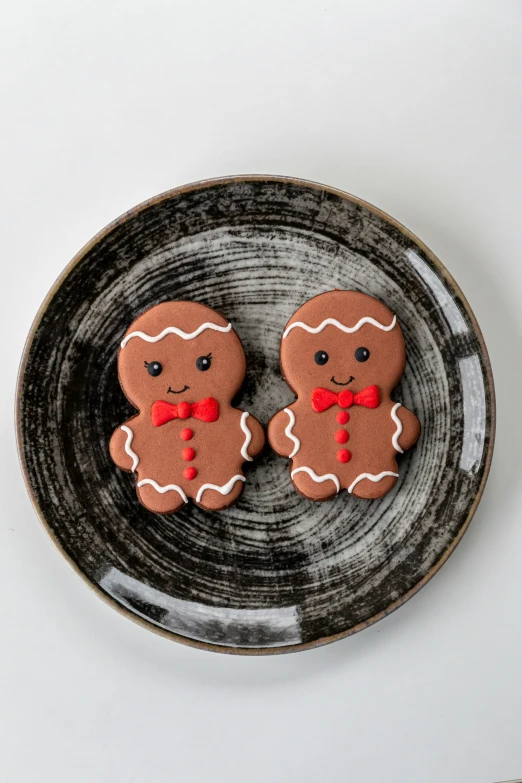 a black and white plate with two small gingerbread cookies