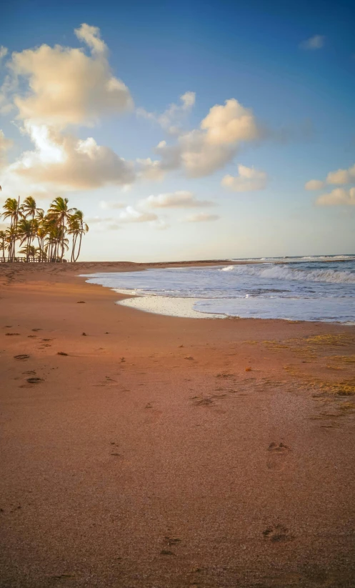 a person sitting on a beach with footprints in the sand