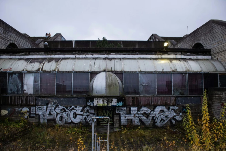 there is a wall covered with graffiti in front of some buildings