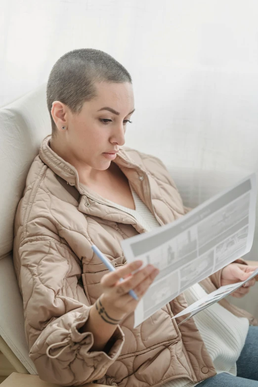 woman with short hair sitting on sofa reading paper