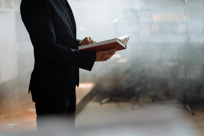 a man wearing a suit standing next to a book