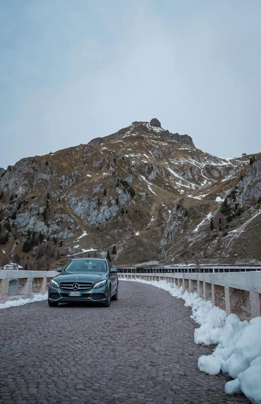 the vehicle is driving up the road near a mountain