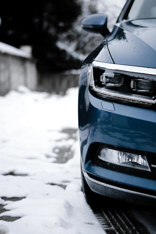 the front view of a blue car parked on snow