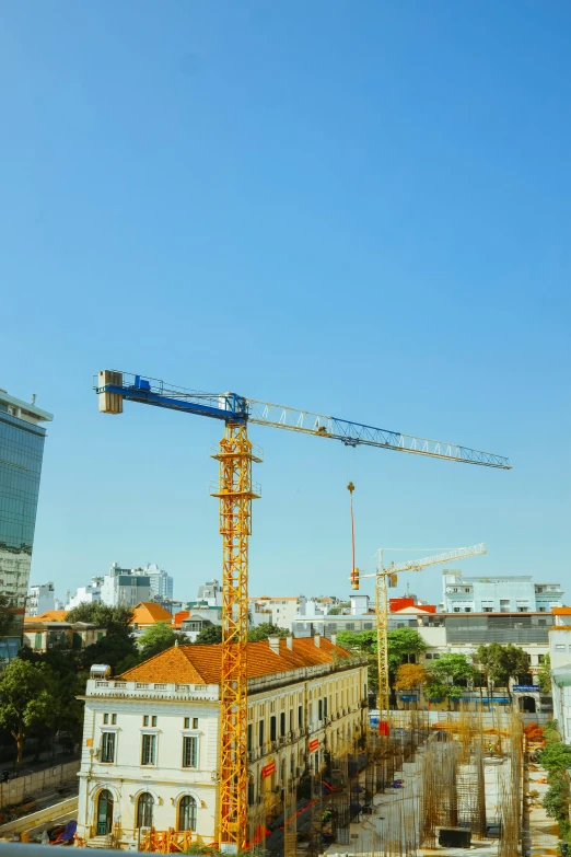 a construction site with large cranes and buildings in the distance