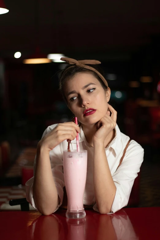 a woman in a white shirt sitting at a red table