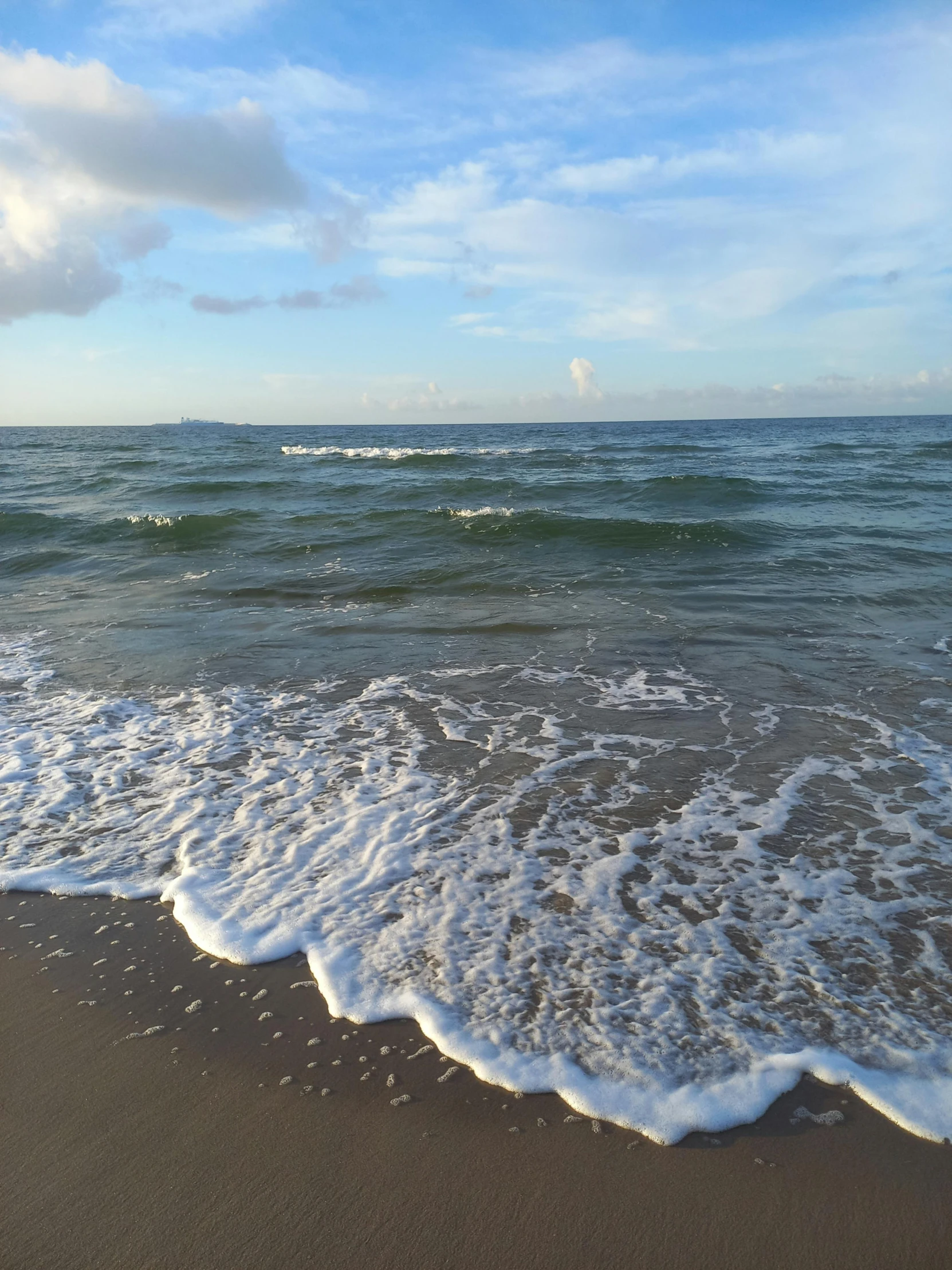 waves coming in on the shore line next to an ocean