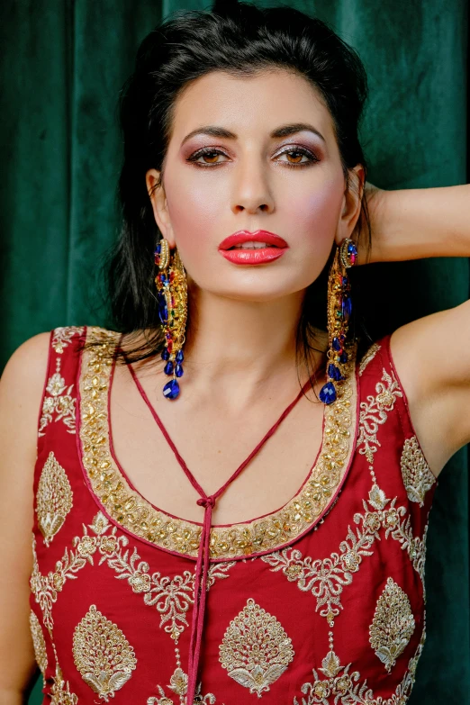 a woman with a red and gold outfit is posing