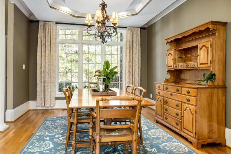 a wooden table surrounded by chairs in a large room