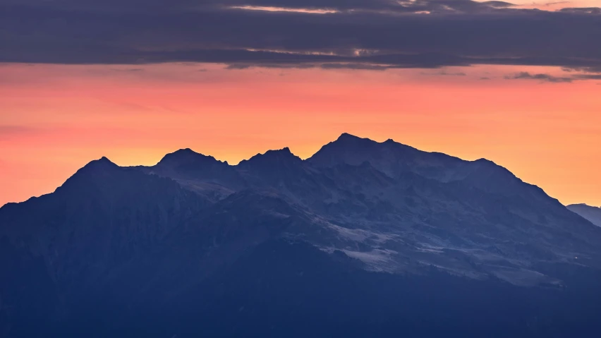 mountains rising above with a bird on top at sunrise