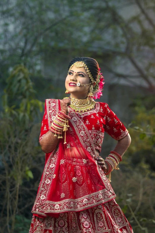 an indian bride in red holding onto a golden cross