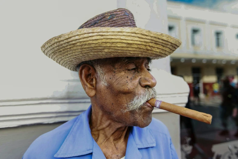 a man wearing a straw hat smoking a cigarette