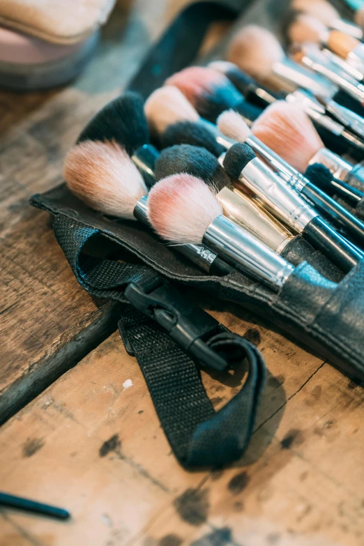 there are many brushes on a bag on a wooden surface