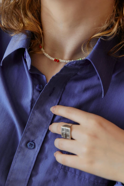 a woman wearing a blue shirt and a ring on her left hand