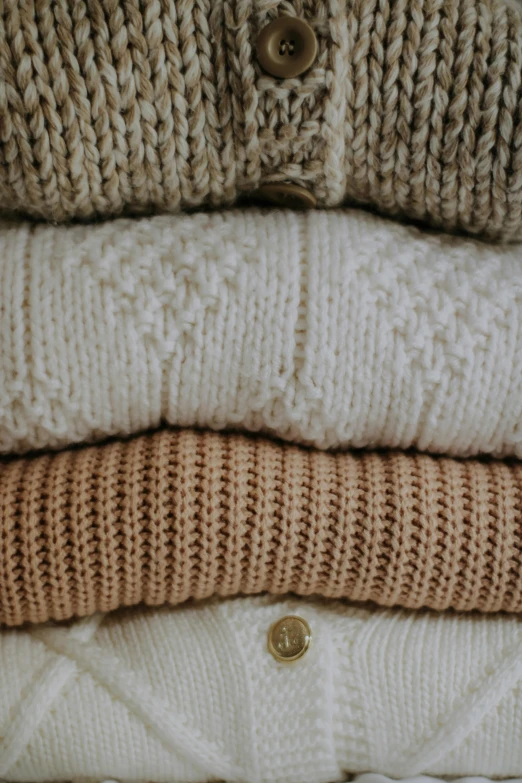 three sweaters that are stacked next to each other