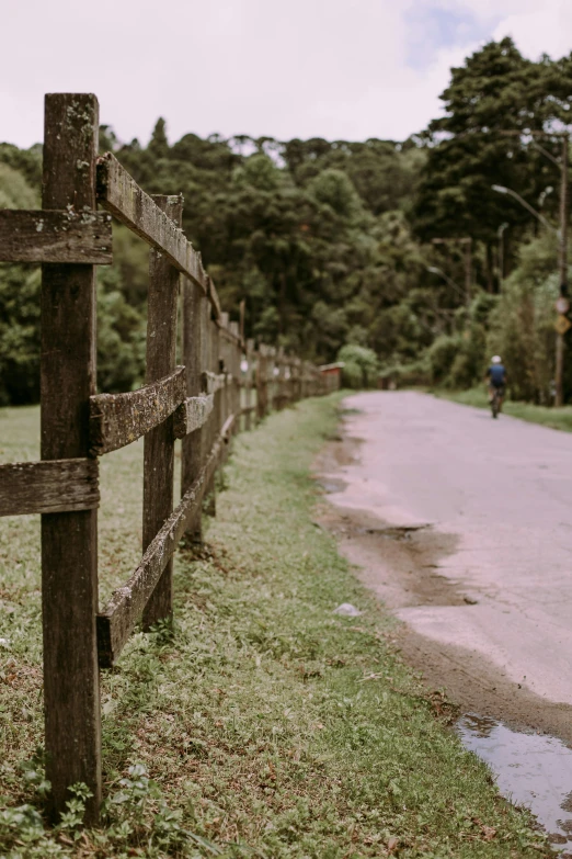 a wooden fence near the side of the road