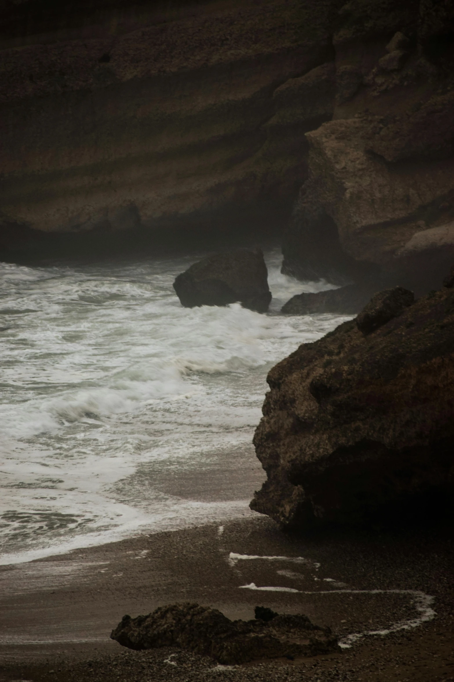 a man walking along a beach next to the ocean