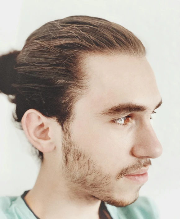 a man with his hair in a messy topknot