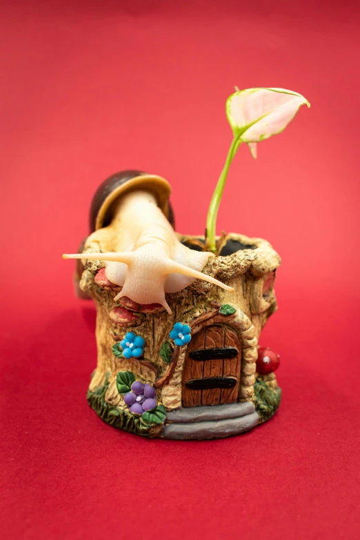 a small fairy house with a flower growing from the outside