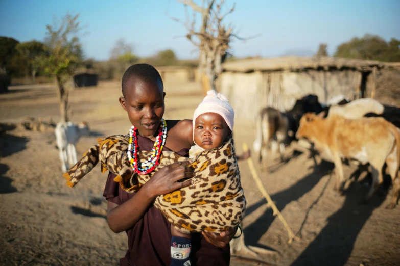 two young children are posing with some animals