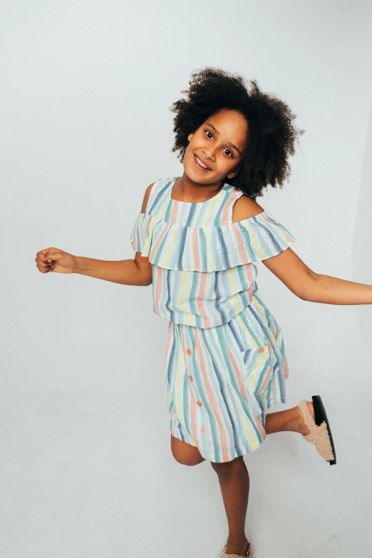 a girl in a dress standing in the studio