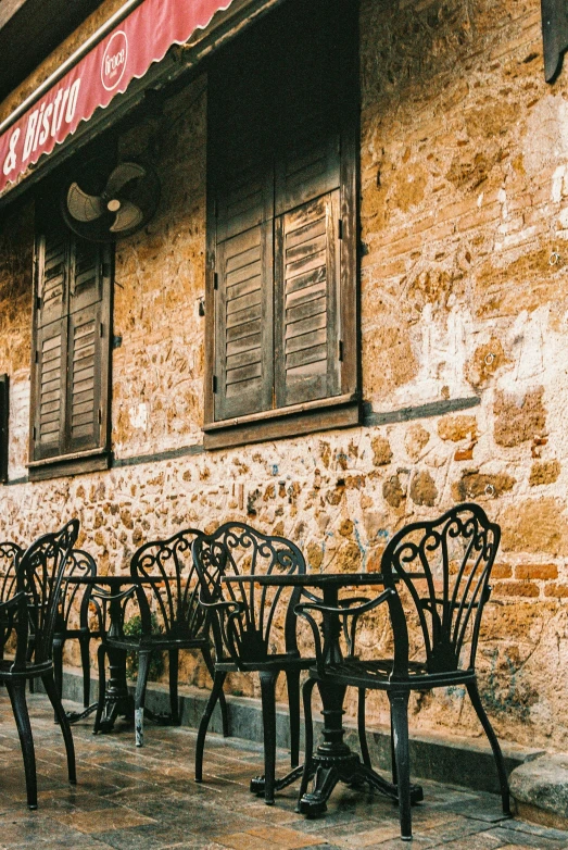 tables and chairs sitting outside of a restaurant