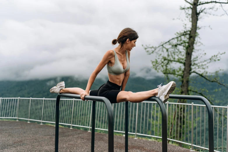 a woman stretching on the edge of a railing