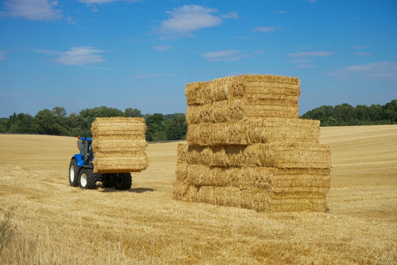 a tractor parked near bales of hay in a field