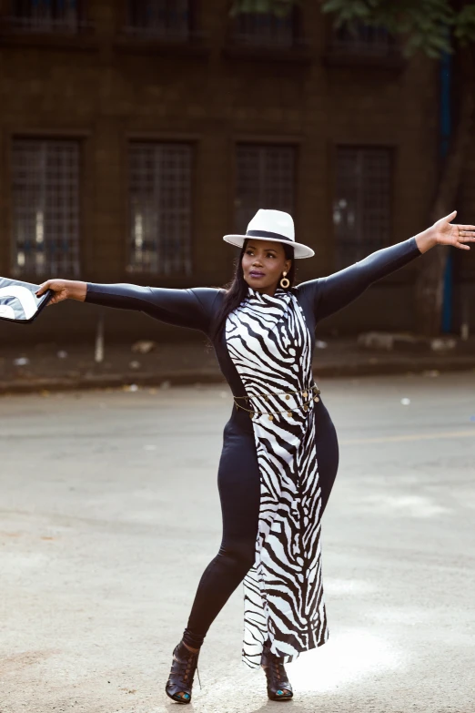 a woman with her arms outstretched, standing on the street