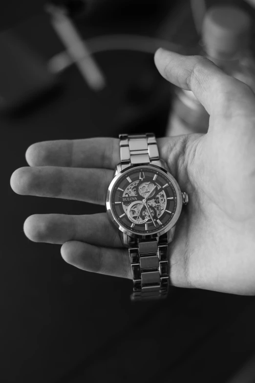 a person holding onto their watch while wearing a celet